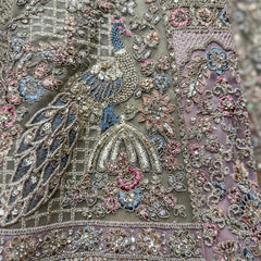 Close-up of sage green lehenga embroidery with peacock and floral motifs