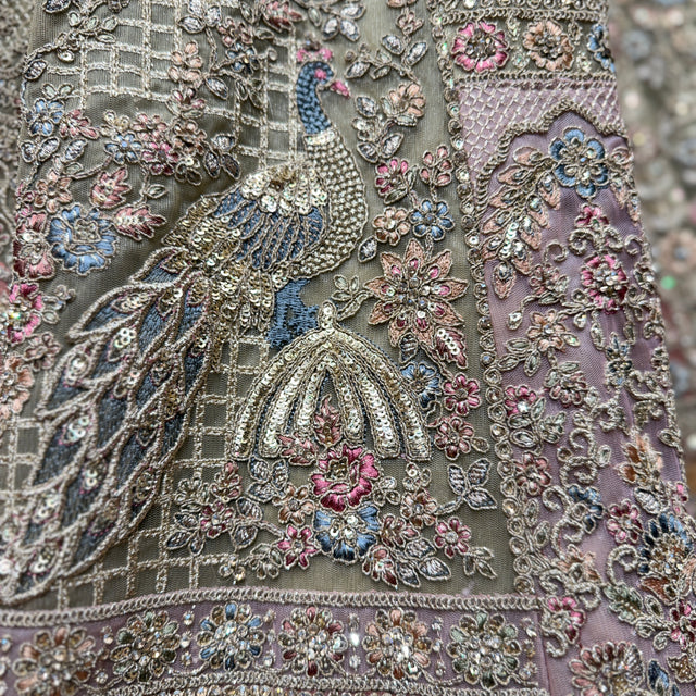 Close-up of sage green lehenga embroidery with peacock and floral motifs