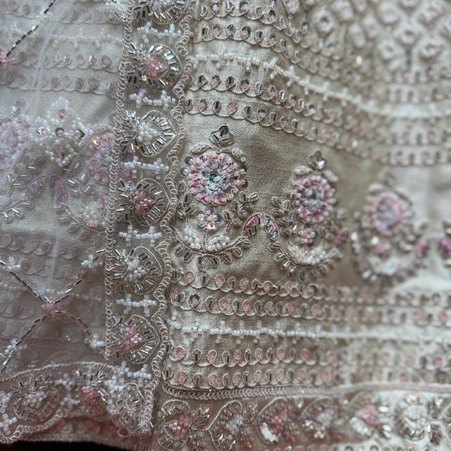 Ivory lehenga fabric close-up with silver, bead and floral sequin embroidery