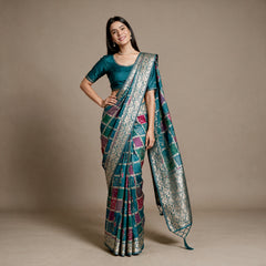 Teal-blue silk saree with patchwork panels and zari floral border, draped look
