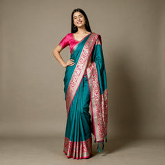 Teal art silk saree with rani pink floral border and patterned pallu, draped