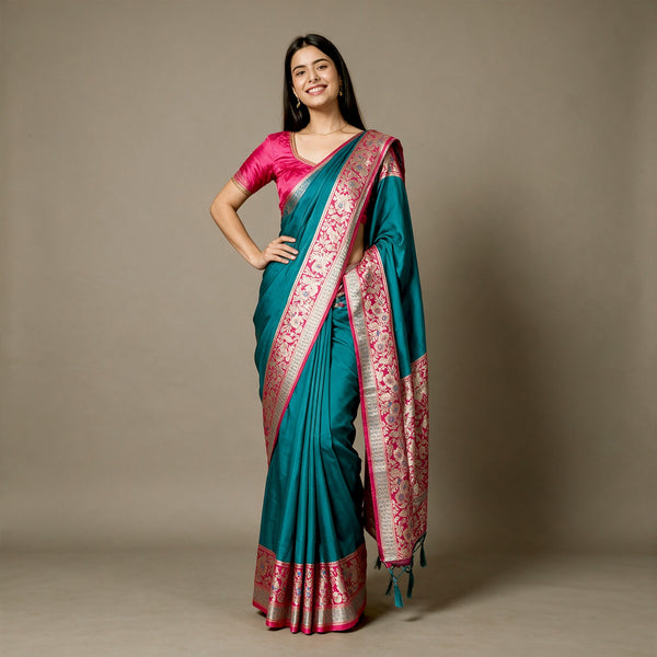 Teal art silk saree with rani pink floral border and patterned pallu, draped