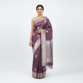 Burgundy saree draped with wide silver-tone border, woven motifs, and fringe end