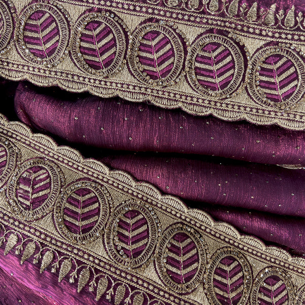 Closeup of wine tissue border with zari embroidery and round stone motifs