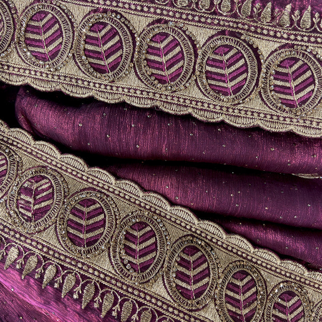 Closeup of wine tissue border with zari embroidery and round stone motifs