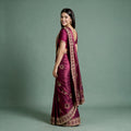 Wine tissue saree with zari and stonework border, ornate pallu, draped on model