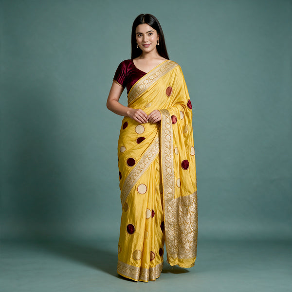 Yellow silk saree with velvet polka dots and gold zari border, draped pallu