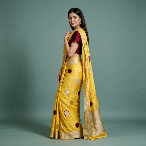 Yellow silk saree with scattered polka dots and gold zari border, side drape