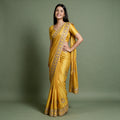Yellow tissue saree with zari and stone work border