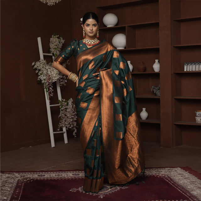 Teal silk saree with copper zari border and geometric square motifs, worn draped