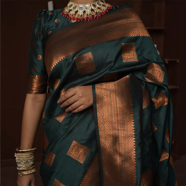 Teal silk saree close-up with copper zari border, square motifs, and patterned pallu
