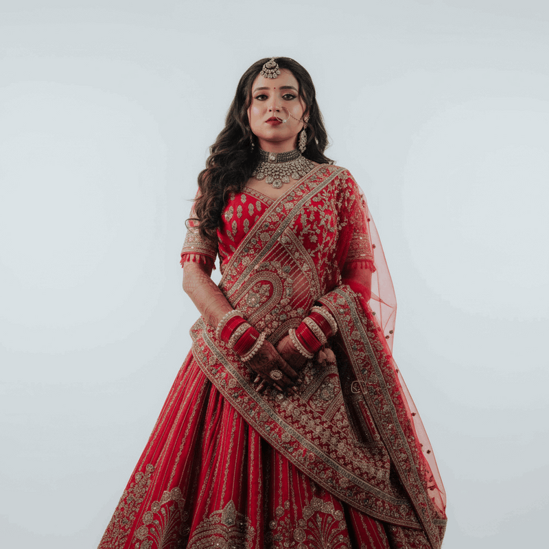 Red bridal lehenga with flared skirt, gold-and-silver embroidered border and dupatta